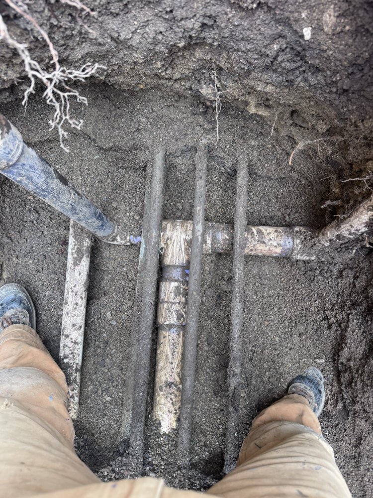 Multiple underground water and drain pipes exposed for repair by 5Star Plumbing Plus in a Dubuque, IA yard